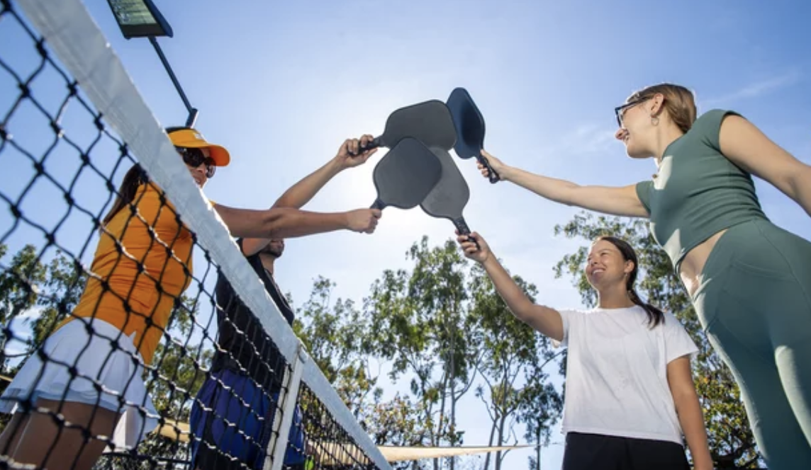 Pickleball players celebrating together at the net