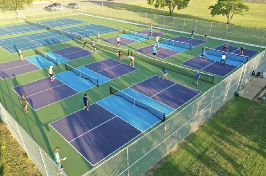 Multiple outdoor pickleball courts with players